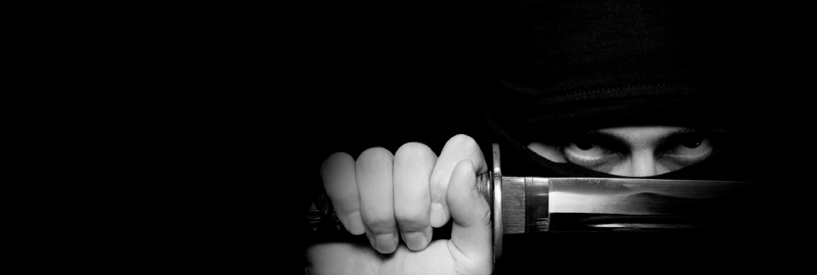 Focused man’s eyes peering over a samurai sword, symbolizing discipline and mastery in Spacemakers' Email Ninja Training for email management and productivity